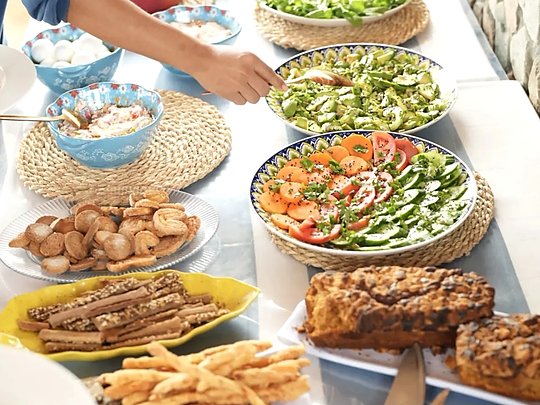 ترابيزة إفطار عليها سلطات وجبن ومخبوزات بلدي في أطباق مزخرفة